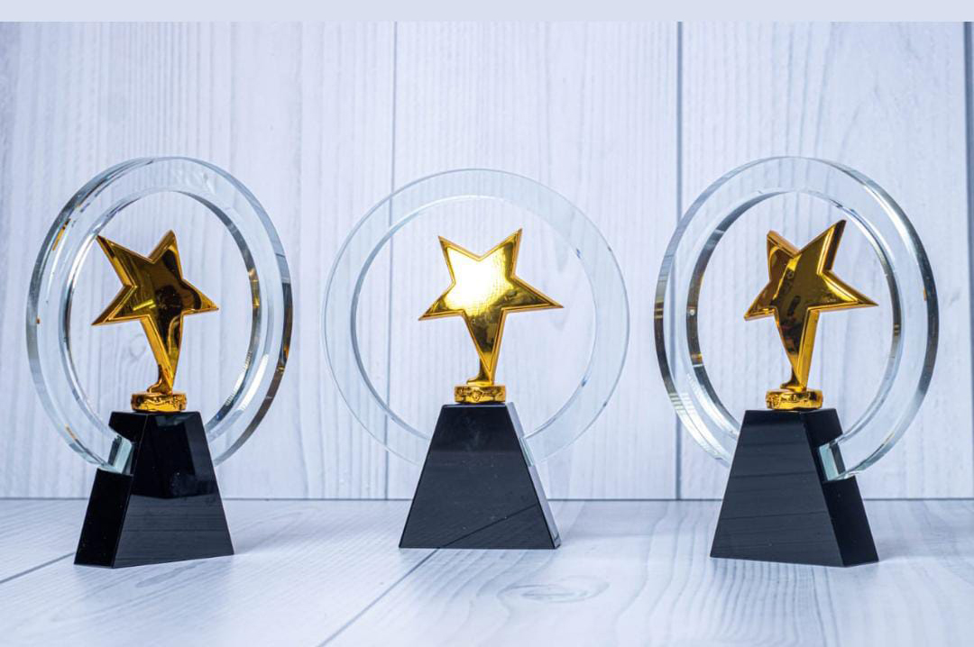 Crystal and acrylic award engraving in Nairobi by Almasi Prints, circular crystal awards with gold star centres on black bases