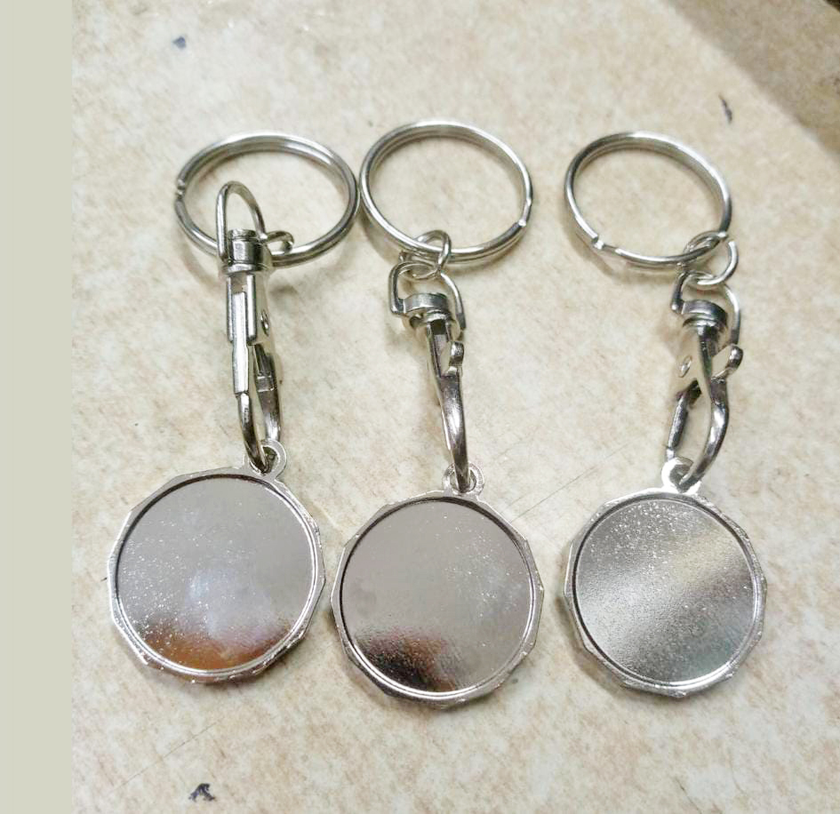 Metal keyholder engraving in Nairobi by Almasi Prints, round polished metal keyholders with trigger clips ready for engraving