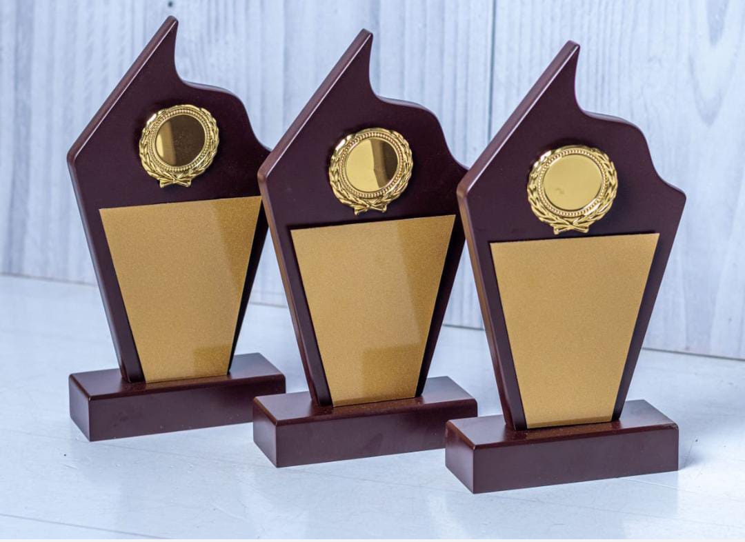 Wooden shield award engraving in Nairobi by Almasi Prints, timber shield awards with gold plates and wreath medallions